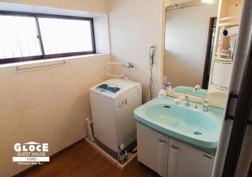 a bathroom with a sink and a washer and dryer at GLOCE 養老 西小倉ハウス 1 l 広々とした一軒家を貸切 l 無料駐車場有 l 中長期向け in Yoro