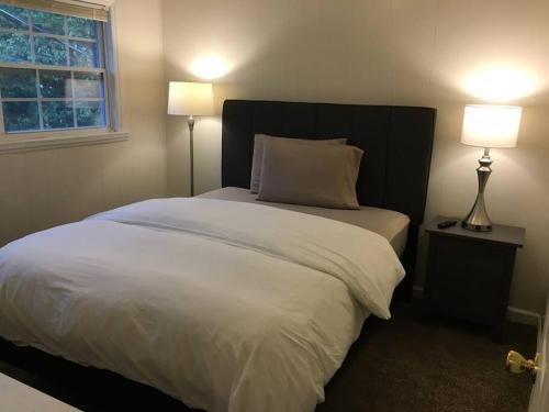 a bedroom with a large white bed with two lamps at Suite 4, Sleep 6, Walk to Attractions in Uptown in Charlotte