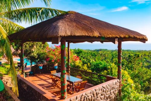 a pavilion with a table and chairs on a roof at Marqis Sunrise Sunset Resort and Spa in Baclayon