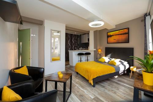 a bedroom with a yellow bed and a living room at Studi'o Soleil in Cannes