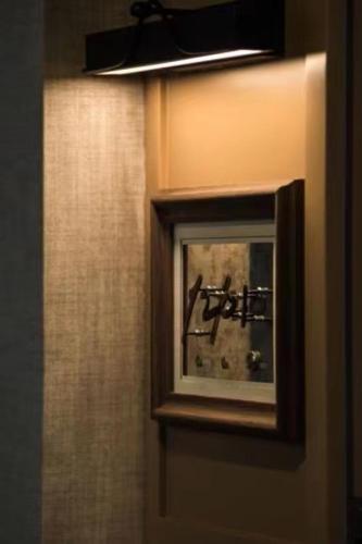 a mirror on the wall of a bathroom at Mia Hotel - Shanghai Shaanxi South Road in Shanghai