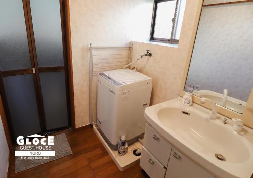 a bathroom with a sink and a toilet and a mirror at GLOCE 養老 西小倉ハウス 2 l 広々とした一軒家を貸切 l 無料駐車場有 l 中長期向け in Yoro