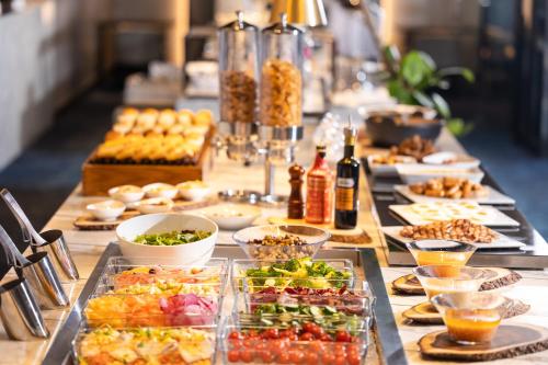 a long table filled with plates of food and drinks at Cross Hotel Osaka in Osaka