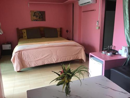 a bedroom with a bed in a pink room at Grand Tree in Ko Chang