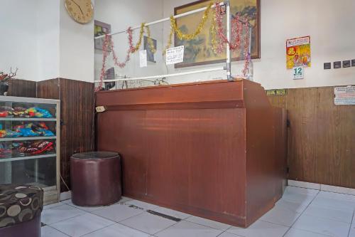 a large wooden door in a store with a trash can at Hotel O Diamond Inn Makassar in Makassar