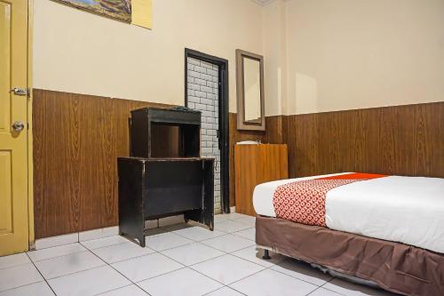 a bedroom with a bed and a tv in it at Hotel O Diamond Inn Makassar in Makassar