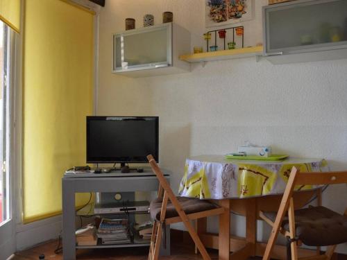 Cette chambre dispose d'une table, d'une télévision, d'une table et de chaises. dans l'établissement Studio Climatise avec Terrasse à Saint-Cyprien - Animaux Admis, Parking - FR-1-225D-434, à Saint Cyprien Plage