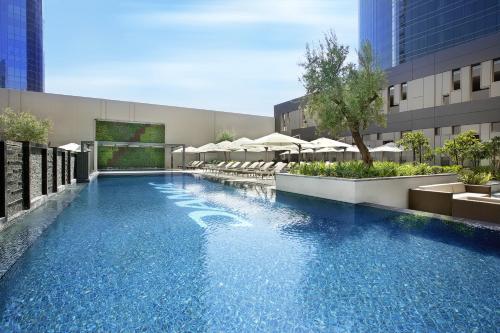 a swimming pool with umbrellas on a building at DAMAC Maison Cour Jardin in Dubai