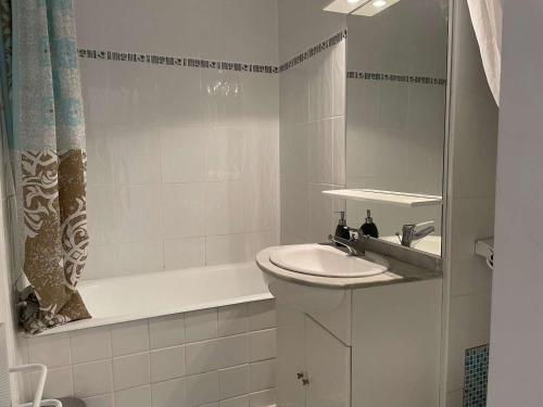 une salle de bain blanche avec un lavabo et une baignoire dans l'établissement Studio avec jardinet, proche plage et commerces, La Guérinière - FR-1-224B-594, à La Guérinière