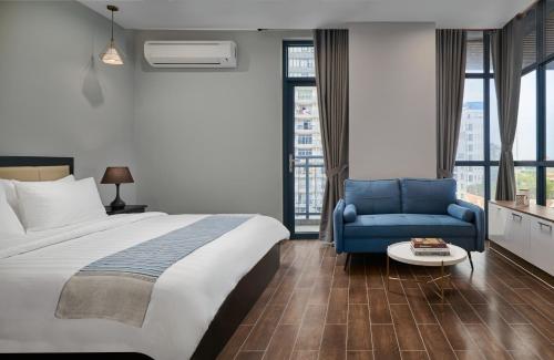 Pokój hotelowy z łóżkiem i niebieskim krzesłem w obiekcie BIJOU Serviced Residence w mieście Phnom Penh