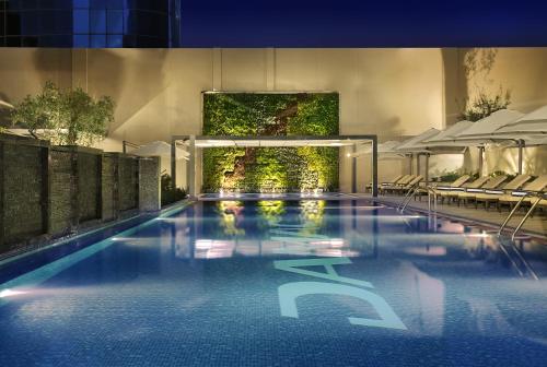 a large swimming pool with a large mirror in the middle of it at DAMAC Maison Cour Jardin in Dubai