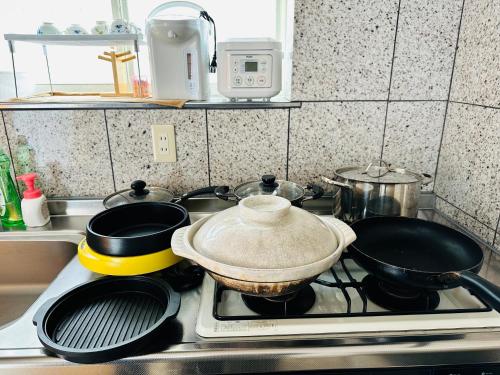 a kitchen stove with pots and pans on it at Shanshui House Shin asahi in Takashima