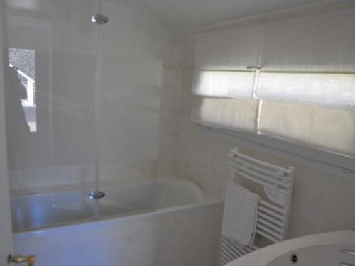 une salle de bain blanche avec une baignoire et un lavabo dans l'établissement Maison de charme au bord de l'eau à Perros-Guirec - FR-1-368-198, à Perros-Guirec