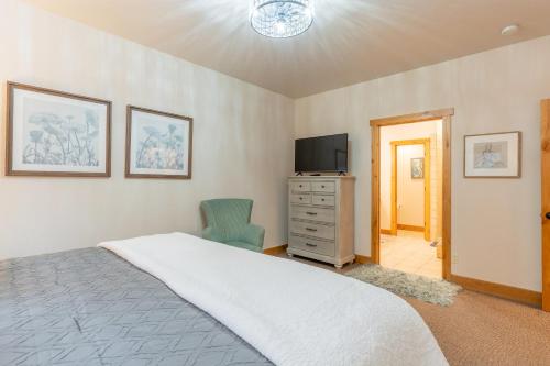 a bedroom with a bed and a tv and a chair at Juniper Bay Getaway in Somers