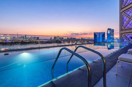 a swimming pool on top of a building with a city skyline at Al Bandar Arjaan by Rotana – Dubai Creek in Dubai