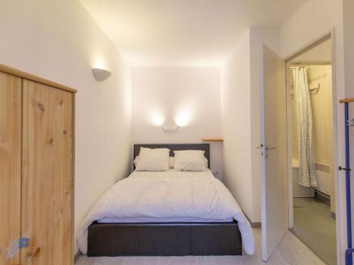 Cette petite chambre comprend un lit avec des draps blancs. dans l'établissement 