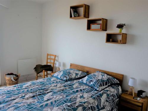 Schlafzimmer mit einem Bett mit einer blauen und weißen Bettdecke in der Unterkunft Appartement Perros-Guirec, 2 pièces, 4 personnes - FR-1-368-293 in Perros-Guirec