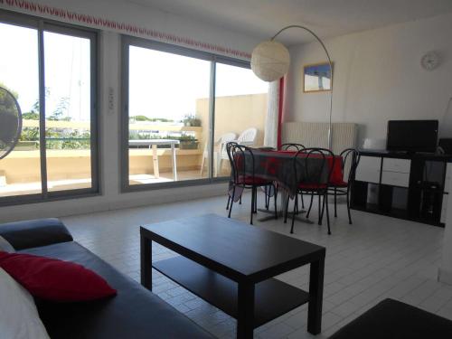 un salon avec un canapé, une table et des chaises dans l'établissement Marina Duplex 4 couchages, Terrasse et Solarium, Clim, Wifi, Parking, Port Camargue - FR-1-250-217, au Grau-du-Roi