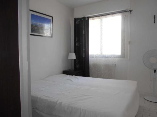 une chambre avec un lit blanc et une fenêtre dans l'établissement Marina Duplex 4 couchages, Terrasse et Solarium, Clim, Wifi, Parking, Port Camargue - FR-1-250-217, au Grau-du-Roi