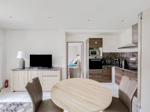 - une cuisine avec une table ronde en bois et des chaises dans l'établissement Appartement avec grande terrasse, WIFI, proche port et commerces, Perros-Guirec - FR-1-368-338, à Perros-Guirec