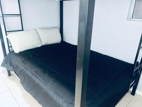 a black bunk bed with a white pillow on it at The Doze Off in Houston