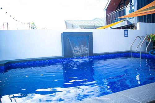 a swimming pool with a water fountain on a building at Hidden Haven Subic Villa w/ Infinity Pool in Subic