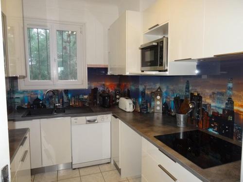 une cuisine avec des armoires blanches et un comptoir dans l'établissement Appartement 3 chambres à 30m de la mer avec terrasse et parking, Hyères Plage - FR-1-335-92, à Hyères