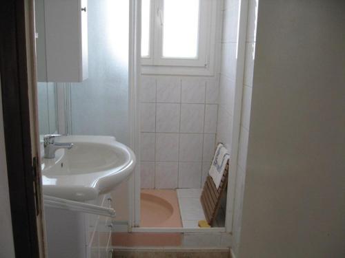 une salle de bain blanche avec un lavabo et une fenêtre dans l'établissement Appartement 3 chambres à 30m de la mer avec terrasse et parking, Hyères Plage - FR-1-335-92, à Hyères
