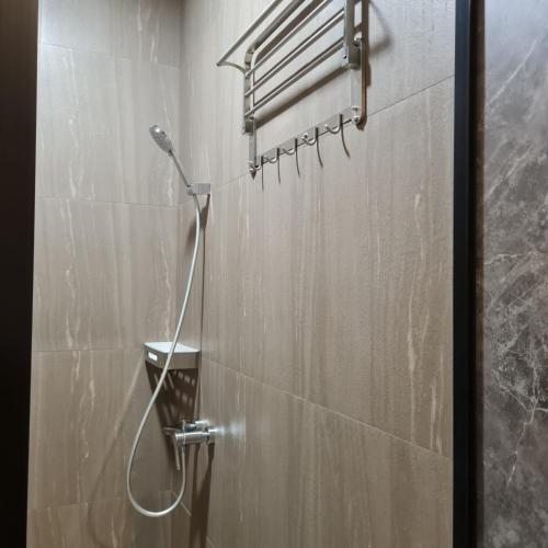 een douche in een badkamer met een douchekop bij 3 Point Syariah Residence in Jakarta
