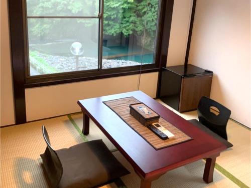 a room with a table and a chair and a window at SyunkaSyuutou - Vacation STAY 53638v in Hakone