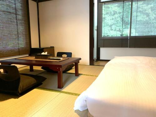 a bedroom with a table and a bed and a bed at SyunkaSyuutou - Vacation STAY 53638v in Hakone