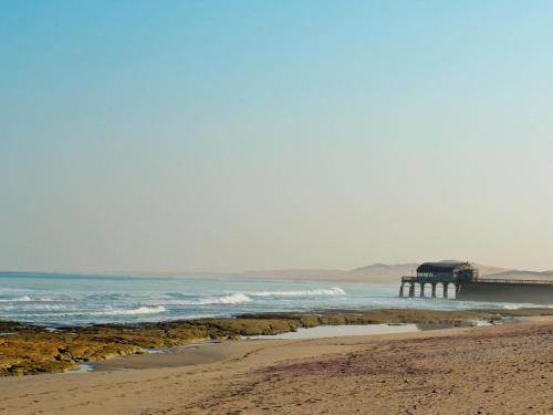 a view of a beach with a pier in the water at Burning Shore Hotel in Langstrand