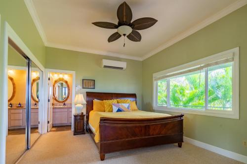 a bedroom with a bed and a ceiling fan at Hideaway Cove Poipu Beach in Koloa