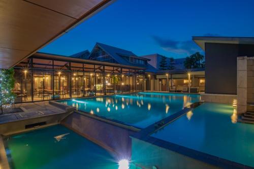 a swimming pool in a hotel at night at AMANE resort GAHAMA in Beppu