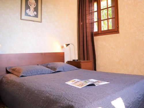 - une chambre avec un lit et un magazine dans l'établissement Appartement 2 pièces avec parking près de la plage - FR-1-251-348, au Lavandou