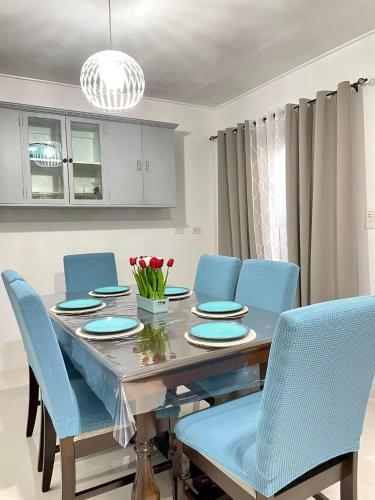 a dining room with a table and blue chairs at Ana's Haven Olongapo/Subic (East Bajac-Bajac) in Olongapo