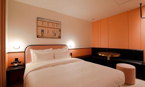 a bedroom with a large white bed and a table at Hotel Ippda Gumdan in Incheon