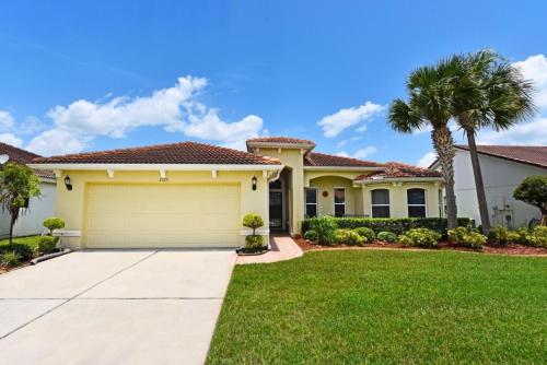 a house with a garage and palm trees at Lovely Lakeside 4-Bed Pool Home at Villa Sol-3125 home in Kissimmee