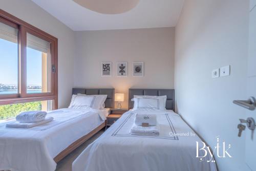 two beds in a white room with a window at BYTK - La Casa Del Sol in Hurghada