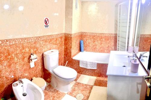 e bagno con servizi igienici, lavandino e vasca. di Apartamento zona Palacio de las Dueñas y las Setas a Siviglia
