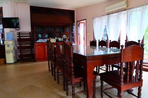 a dining room with a wooden table and chairs at โรงแรม พี รีสอร์ท in Kamphaeng Phet