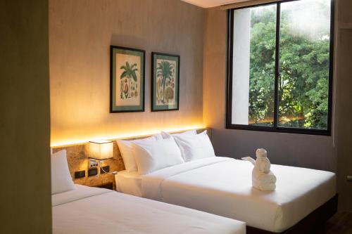 Hotel Dumaguete في دوماغيتي: غرفة فندقية بسريرين ونافذة