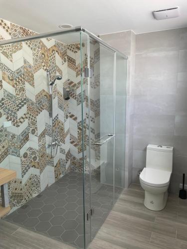 a bathroom with a toilet and a glass shower at Waiting Homestay in Taitung City