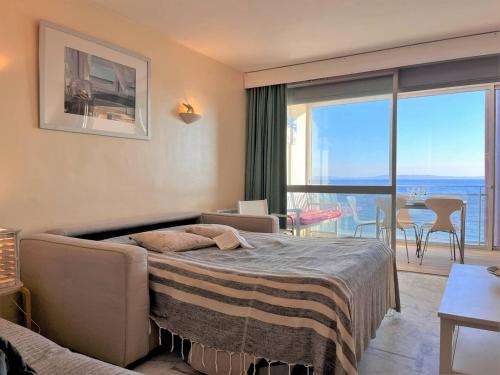une chambre avec un lit et un balcon avec vue dans l'établissement Appartement 2 pièces avec vue mer, plage à Cavalière - FR-1-251-434, au Lavandou