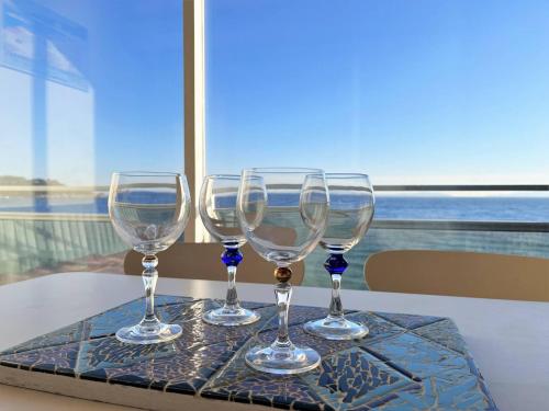 quatre verres à vin assis sur un plateau sur une table dans l'établissement Appartement 2 pièces avec vue mer, plage à Cavalière - FR-1-251-434, au Lavandou