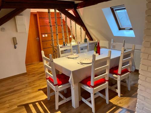 une salle à manger avec une table et des chaises blanches dans l'établissement Le Petit Linck - Typique au coeur de Colmar, à Colmar