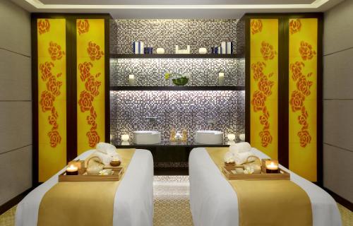 two beds in a room with yellow walls and candles at DAMAC Maison Cour Jardin in Dubai