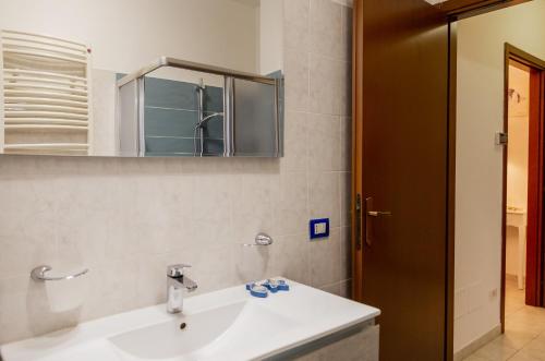 uma casa de banho com um lavatório branco e um espelho. em Casa Erika em Puntone di Scarlino