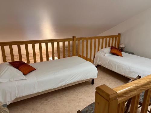 two beds in a room with wooden walls at Chambres d'hôtes Aux Portes des Tumuli in Bussy-le-Château