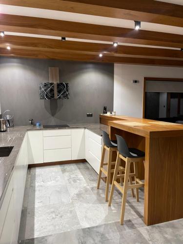 a kitchen with white cabinets and a wooden counter top at Dom Przy Lesie in Istebna